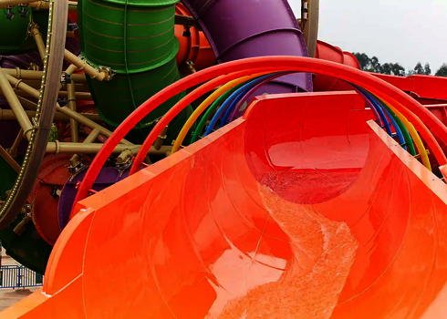 Bunte Wasserrutsche RR2700 mit Regenbogendekor und geschwungenen Rutschenrohren.