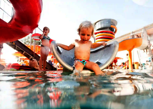 Kind sind fröhlich auf der WR560, Füße baumeln im Kinderbecken.