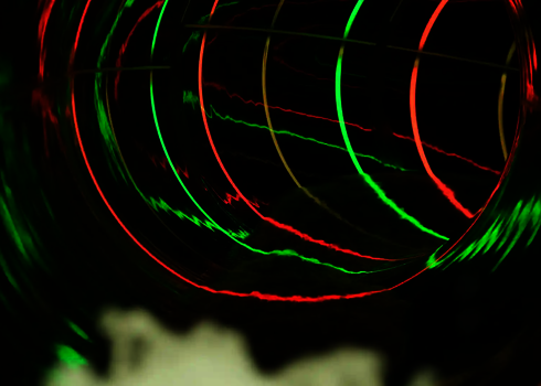 Innenansicht einer dunklen Wasserrutsche mit roten und grünen LED-Lichteffekten.