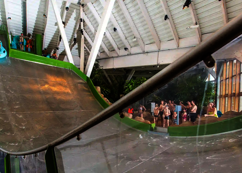 Eine Frau mit Kind startet auf der Sidewinder, im Hintergrund warten Badegäste.