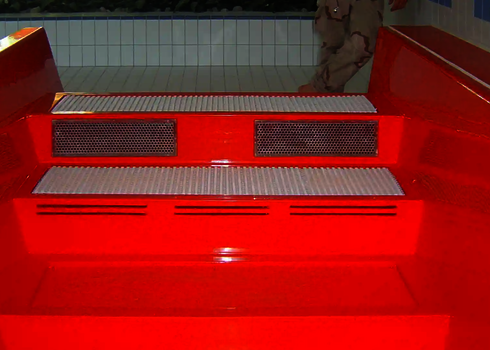 Red drain basin with three non-slip steps and recessed ventilation grilles.