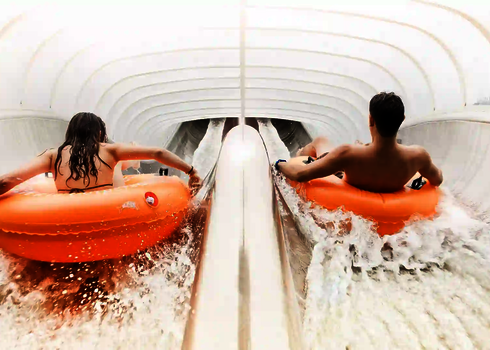 Doppelaufnahme von zwei Rutschenden in orangen Reifen auf der Raft Racer Reifenrutsche.