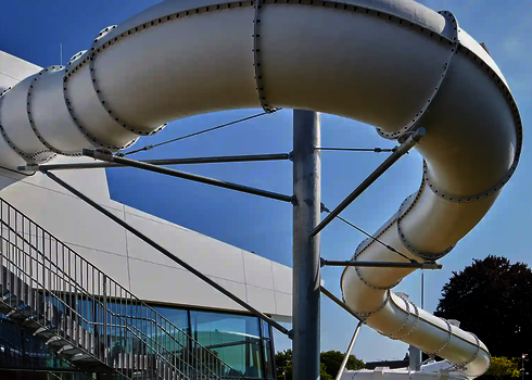 Blick von unten auf eine Wasserrutsche unter freiem Himmel.