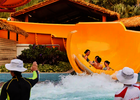 Blick auf mehrerer Personen, die aus einer RR2700 in ein Auslaufbecken rutschen