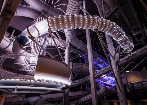Ansicht von unten auf eine spiralförmige Wasserrutsche mit LED-Lichtern und eine Body Bowl Rutsche.