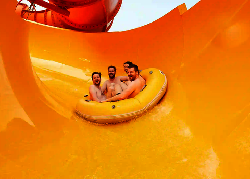 Vier Personen fahren gemeinsam im gelben Rundreifen durch den gelben Trichter der Rutsche RR2700.