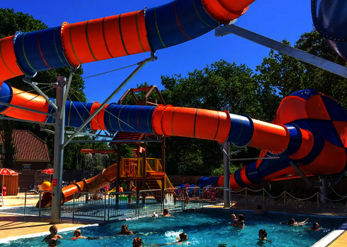 Crazy Cone am Beckenrand mit Badegästen, orange-blaue Röhren führen in den Trichter.