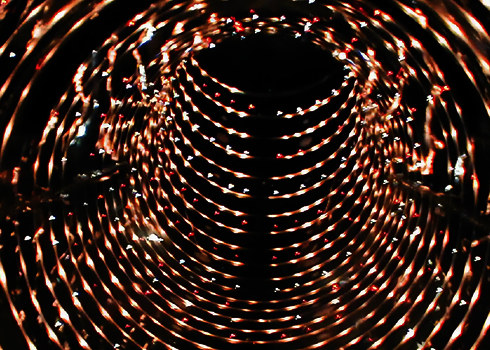 Spiralförmige LED-Lichter in dunklem Rutschentunnel erzeugen einen Tunnelblick-Effekt.