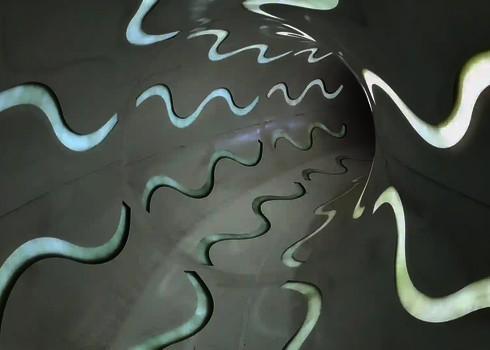 Innenansicht einer Röhrenrutsche mit welligen Tageslichteffekten in weiß.