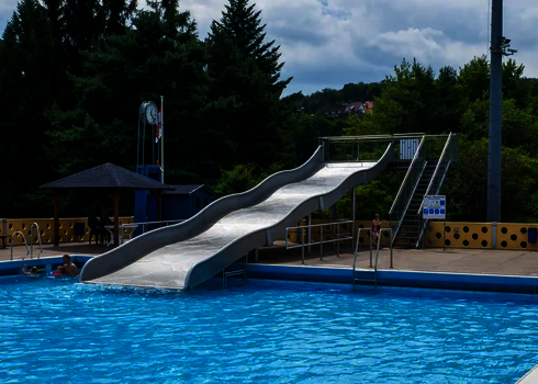 Blick auf eine Breitwellenrutsche in einem Freibad.