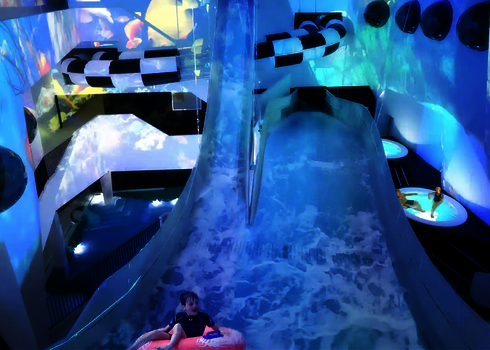 Die Boomerang-Rutsche mit Tunnel und Wellenprojektionen in einem Indoor-Erlebnisbad.