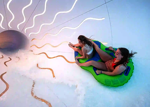 Zwei Mädchen auf einem Reifen in einem hellen Crazy Cone mit Tageslichteffekten.