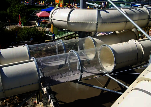 Außenansicht der Raft Racer Wasserrutsche mit transparentem Tunnelabschnitt.