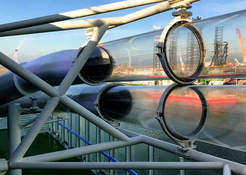 Zwei transparente parallel verlaufende Wasserrutschen oberhalb des Wassers.