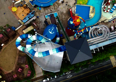 Aerial view of the slide park with raft conveyor, water basin and surrounding facilities.