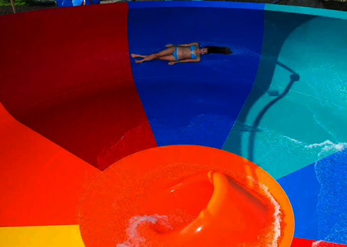 Nahaufnahme eines bunten Body Bowl mit rutschenden Person in Badebekleidung.