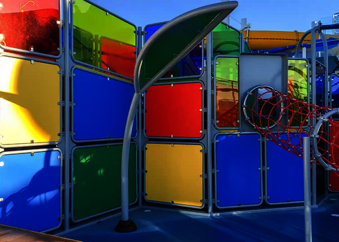 Bunter Wasserspielplatz mit Wie-Spray Elementen und Kletterbereich.