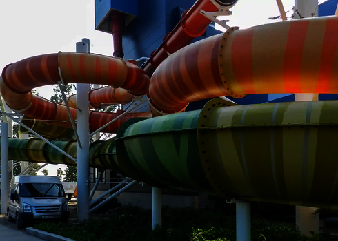 Nahaufnahme bunter Family Twister Wasserrutschen mit Streifen in Grün und Orange.