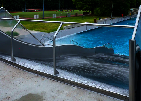 Blick von oben auf eine Breitwellenrutsche in einem Freibad.