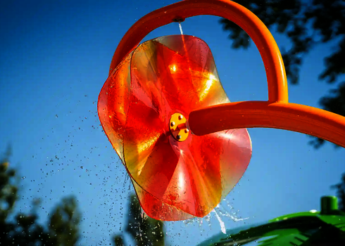 Nahaufnahme des Wie-Spray Bauteils "Blume" mit leicht spritzendem Wasser.