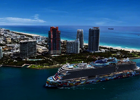 Luftaufnahme der Norwegian Aqua mit Slide Coaster vor der Skyline von Miami Beach.