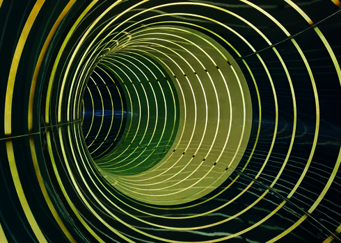 Innenansicht einer dunklen Wasserrutsche mit Lichteffekten in Form von Streifen.