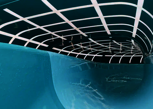 Geschwungene Kurve der 2-in-1 Racer Wasserrutsche mit markanten weißen Linienmustern.