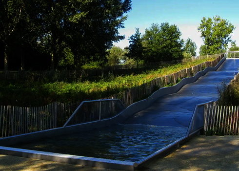 Eine Breitwellenrutsche aus Edelstahl, die in ein Auslaufbecken übergeht.