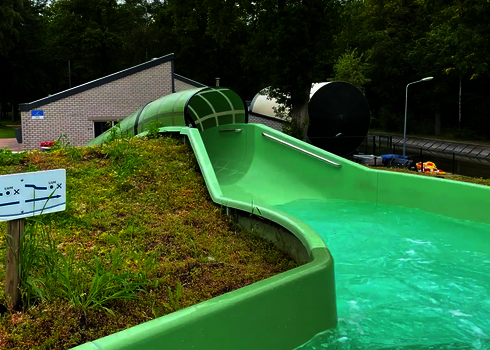 Blick auf einen offenen sowie überdachten Abschnitt eines Wildwasserflusses, im Vordergrund ein Hinweisschild.