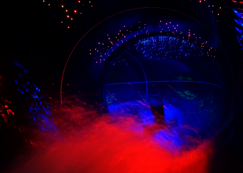 Innenansicht einer Röhre mit rotem Nebel und blauen LED-Sterneneffekten.