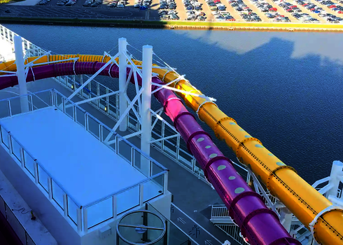 Zwei farbige Wasserrutschen verlaufen parallel auf dem Deck eines Kreuzfahrtschiffes.