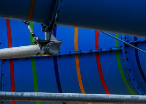 Nahaufnahme einer blauen Wasserrutsche mit bunten Streifen mit Stahlstützen.