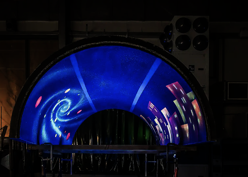 Röhrensegment mit Galaxie- und Stadtsilhouette unter UV-Licht.