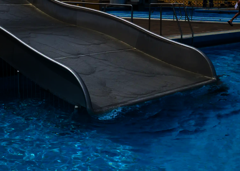 Ende einer Breitwellenrutsche, die in ein Schwimmbecken übergeht.