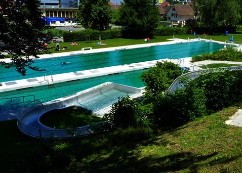 WR1040 Edelstahl-Wasserrutsche endet an einem Becken in einem Freibad.
