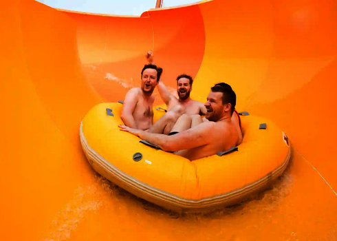 Drei Männer fahren gemeinsam im Reifen durch die orangene Kurve der bunten RR2700.