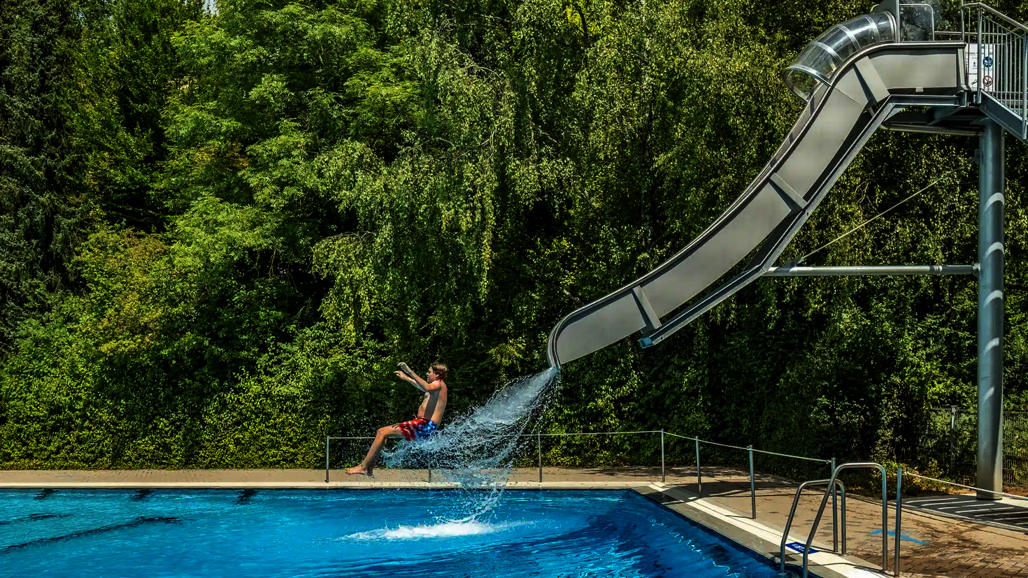 Eine Person in Badebekleidung rutscht die Fallstart Wasserrutsche herunter.