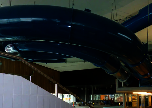 Eine blaue RR1200 Wasserrutsche in einem Hallenbad.