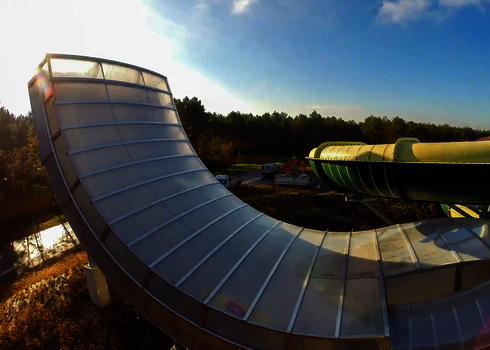 Boomerang-Rutsche im Außenbereich bei Sonnenuntergang, montiert an einem Freizeitbad.
