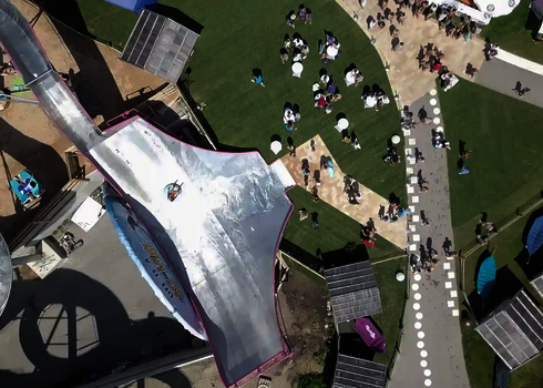 Die Sidewinder-Rutsche in Action, aus der Vogelperspektive mit einem Rutschreifen im Zentrum.