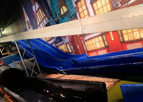 Innenbereich eines Freizeitparks mit unterschiedlichen Rutschentypen.