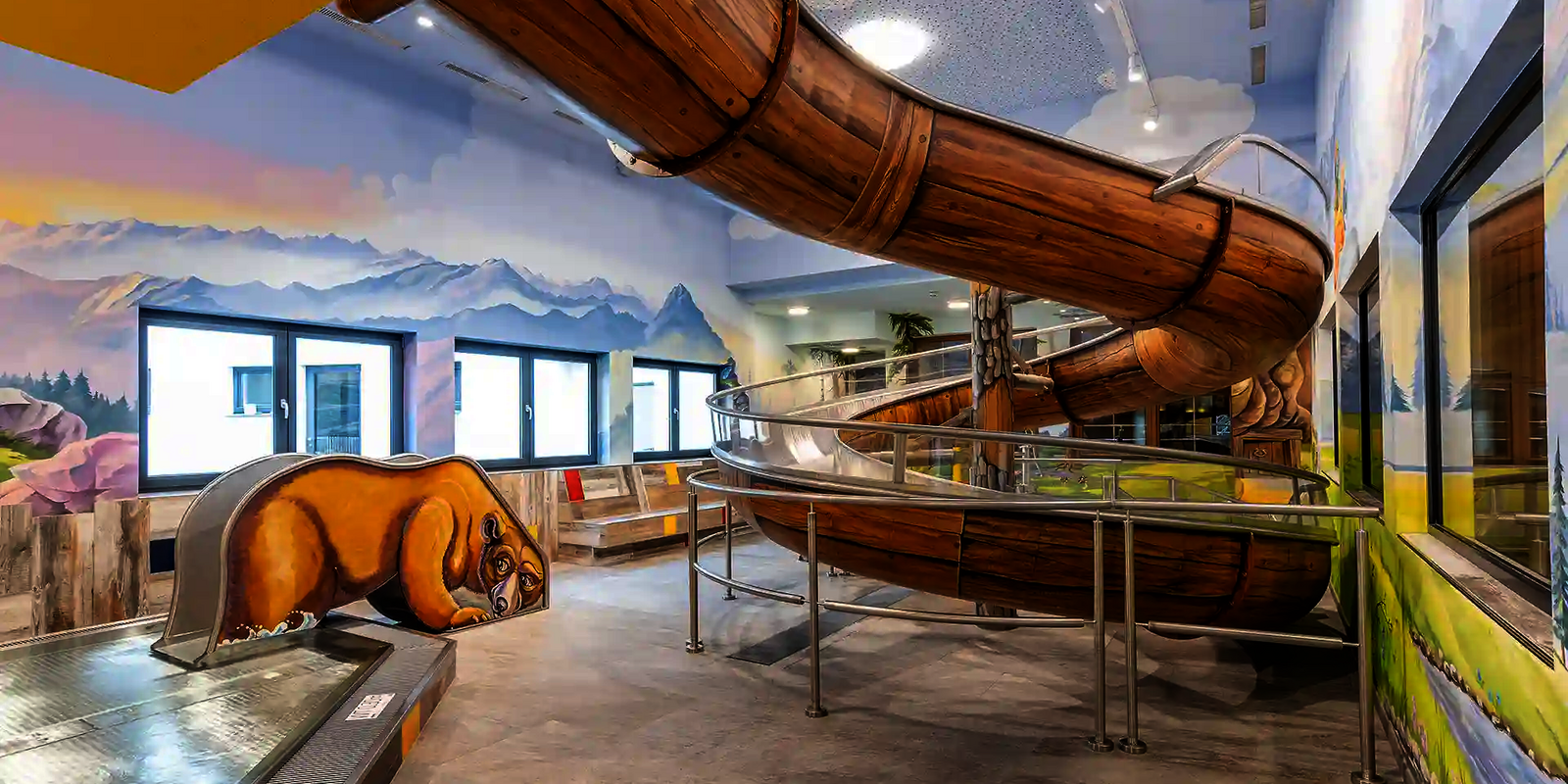 Indoor-Wasserrutsche mit Holzoptik in einer thematisierten Wasserwelt mit Bärenmotiv