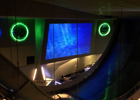 Reifenrutsche Boomerang mit LED-Lichteffekten und steiler Rampe in moderner Indoor-Wasserwelt.