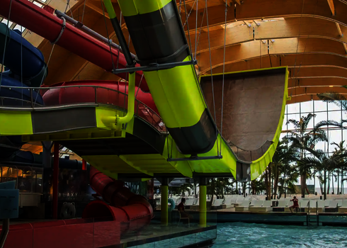 Seitliche Perspektive der Indoor-Boomerang-Rutsche mit stützender Stahlkonstruktion.