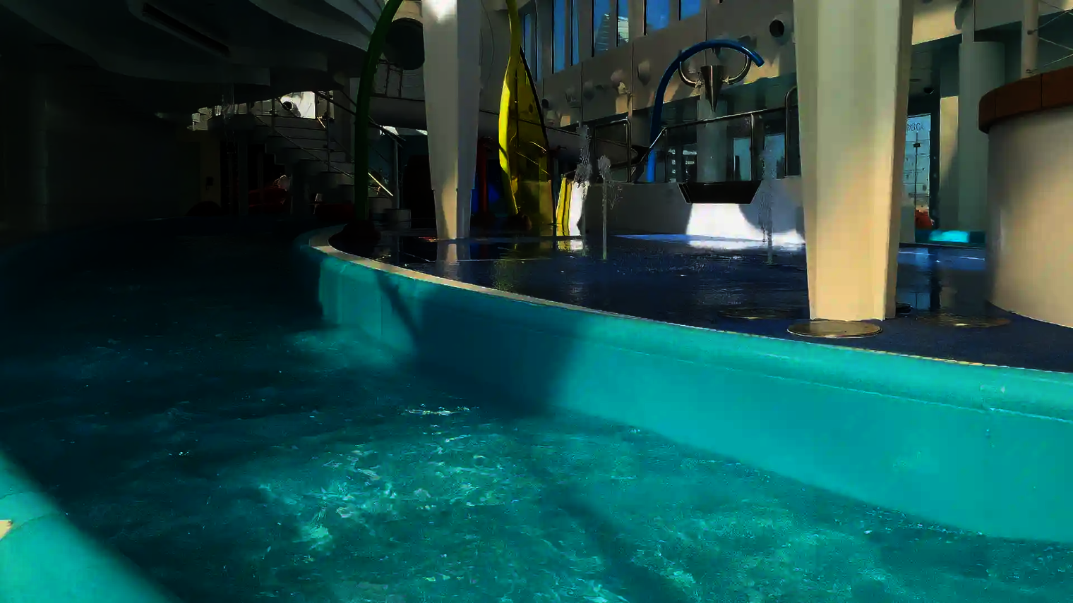 Lazy River mit Wasserattraktionen, bunten Wasserspielen und Wasserdüsen.