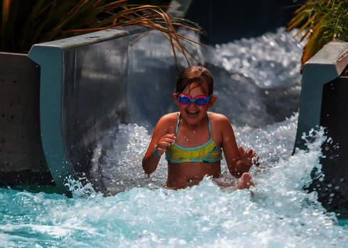 Ein Mädchen erreicht mit Schwung das Ende des Wildwasserflusses.