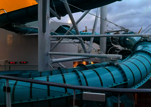 Verschlungene blaue 2-in-1 Racer Wasserrutsche mit markanten Kurven und Verstrebungen.