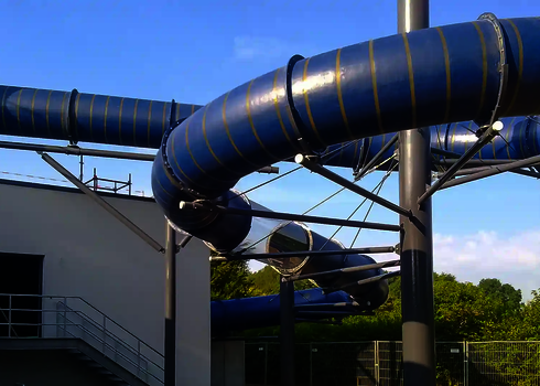 Eine blaue RR1200 Wasserrutsche die von grauen Stahlträgern gestützt wird.