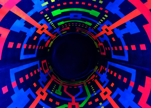 Leuchtende geometrische Muster in Neonfarben unter Schwarzlicht in Röhrenrutsche.