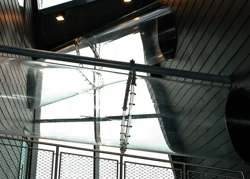 Zwei geneigte Acrylröhren im Innenraum verbinden zwei Etagen mit Tageslichteinfall.